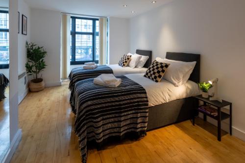 two beds in a room with wood floors at Central Flat-2Bedrooms-2Bath-By FabAccommodation in Bristol