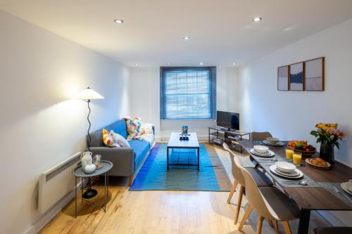 a living room with a blue couch and a table at Central Flat-2Bedrooms-2Bath-By FabAccommodation in Bristol