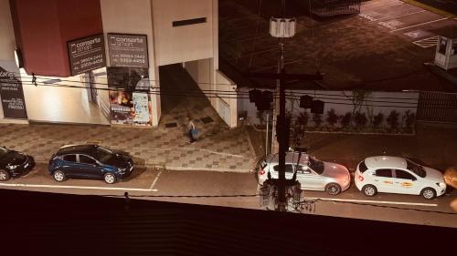 a group of cars parked in a parking lot at Apto no Centro, com Ar Condicionado e Lava e Seca in Cascavel