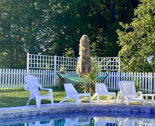 a group of chairs and an umbrella next to a pool at CHATEAU ROUTGER in Sainte Marie de Gosse