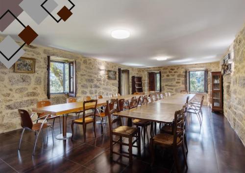 a large room with wooden tables and chairs at Quinta de Ramil in Vieira do Minho