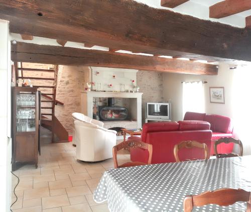 un salon avec un canapé et une cheminée dans l'établissement Maison familiale charmante à Denée avec jardin et loisirs, à Denée