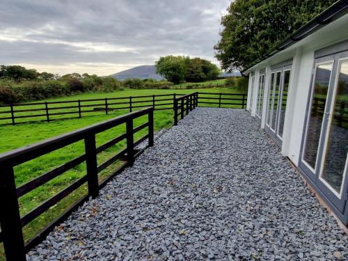 a walkway next to a fence next to a house at Pass the Keys Beautiful Countryside Lodge with Outstanding Views in Dumfries