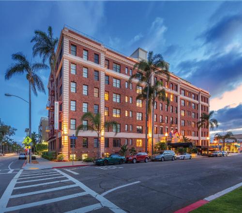 a large brick building on a city street with palm trees at Inn at the Park in San Diego