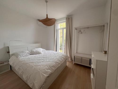 une chambre blanche avec un lit et une fenêtre dans l'établissement Petit paradis perché au coeur de Nice, à Nice