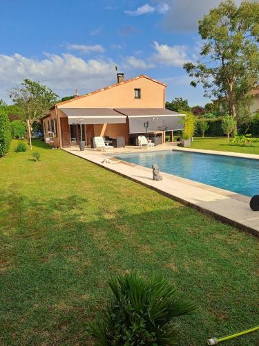 une maison avec une piscine à côté d'une cour dans l'établissement Jolie maison avec piscine, à Labastide-Saint-Georges