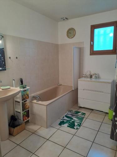 une salle de bain avec une baignoire et un lavabo dans l'établissement Jolie maison avec piscine, à Labastide-Saint-Georges