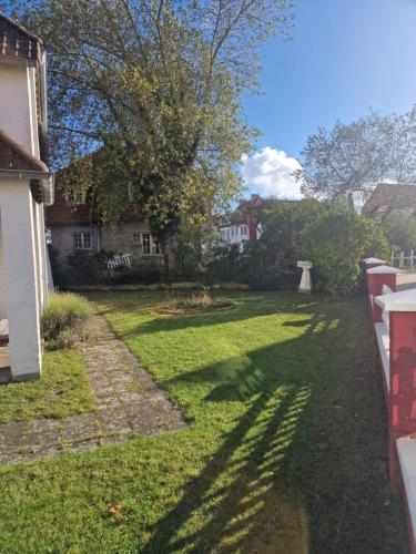a yard with two houses and a tree at Villa Parrain in Koksijde