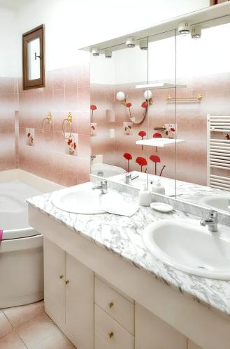une salle de bain avec deux lavabos et un grand miroir dans l'établissement Villa spacieuse à Lioux avec piscine privée et vue montagne, à Lioux