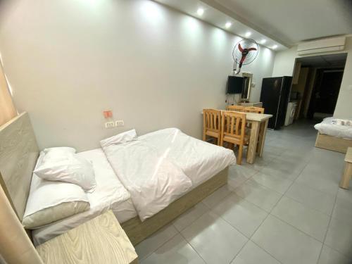 Schlafzimmer mit einem Bett mit weißer Bettwäsche und einem Tisch in der Unterkunft Scandic resort سكانديك ريزورت in Hurghada