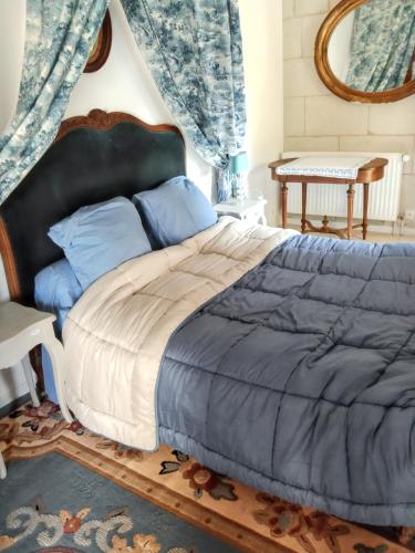 une chambre avec un grand lit et un miroir dans l'établissement Maison charmante à Courchamps avec vue sur jardin, à Courchamps