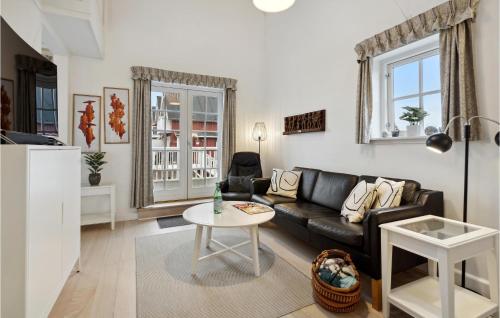 a living room with a black couch and a table at Two-Bedroom Apartment In Grasten in Gråsten