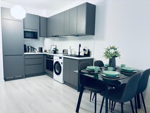 a kitchen with a table and chairs and a kitchen with a dishwasher at Adam Residence in Oradea