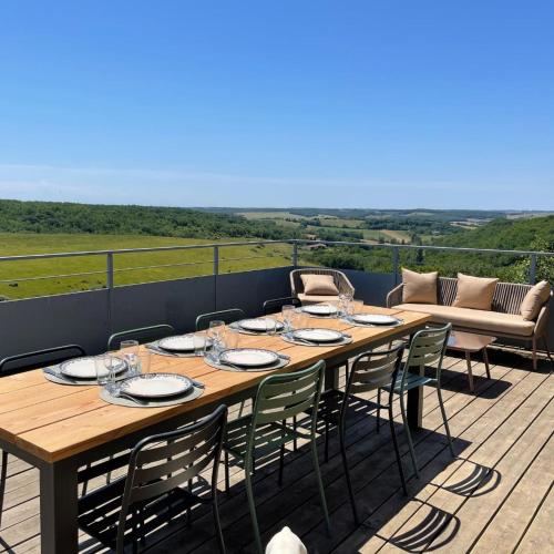 a wooden table and chairs on a deck at Hitton Séjours Nature in Biran