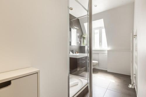 une salle de bain blanche avec une douche et un lavabo dans l'établissement Hoche - Studio - 2 people, à Paris