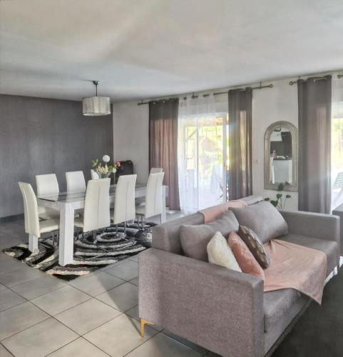 un salon avec un canapé, une table et des chaises dans l'établissement Villa familiale à Bazac avec piscine privée, à Bazac