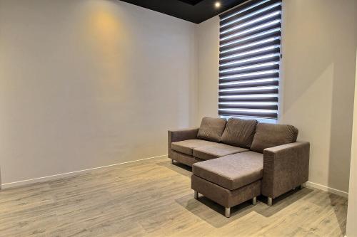 a living room with a couch and a stool at Gare 84 E Charleroi-airport in Charleroi
