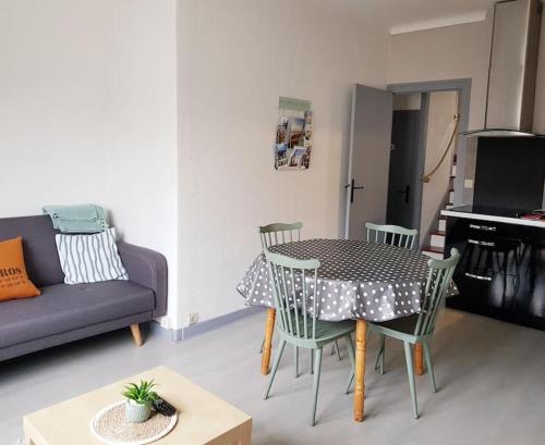 un salon avec une table, des chaises et un canapé dans l'établissement chez Jérome et Elodie, à Perros-Guirec