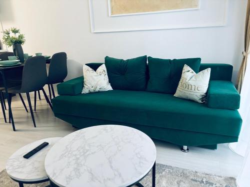 a living room with a green couch and a table at Adam Residence in Oradea