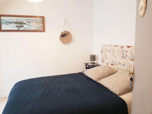 une chambre avec un lit avec une couverture bleue dans l'établissement chez Jérome et Elodie, à Perros-Guirec