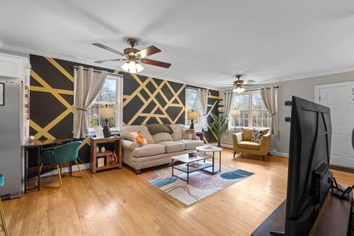 a living room with a couch and a ceiling fan at Spacious-5 Beds! 3 Mi to Mohegan in Uncasville
