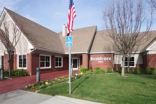 a house with an american flag in front of a building at Residence Inn San Jose South/Morgan Hill in Morgan Hill