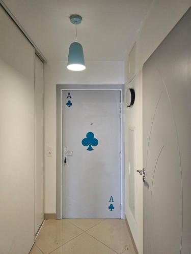 un couloir avec une porte munie d'un autocollant nuageux. dans l'établissement POP ART Casino vibe!, à Gruissan