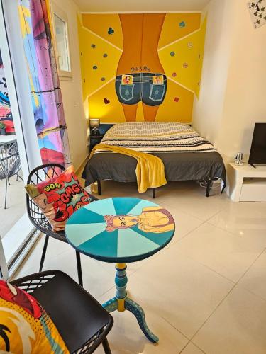une chambre avec un lit et une table et un lit dans l'établissement POP ART Casino vibe!, à Gruissan