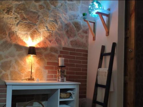 a room with a fireplace and a table with a lamp at Kryptàdion in Grottaglie