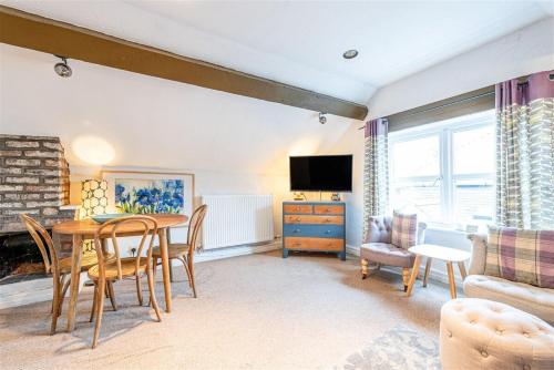a living room with a table and chairs and a television at Apartment on Watergate Street By Cheshire Escapes in Chester
