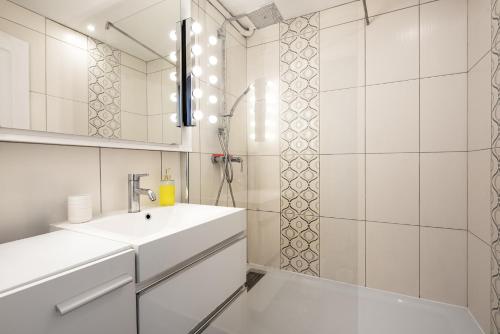 une salle de bain blanche avec un lavabo et une douche dans l'établissement T3 Centre ville à 2 pas du métro - parking gratuit, à Toulouse