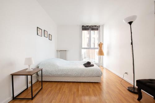 - une chambre blanche avec un lit et une lampe dans l'établissement T3 Centre ville à 2 pas du métro - parking gratuit, à Toulouse