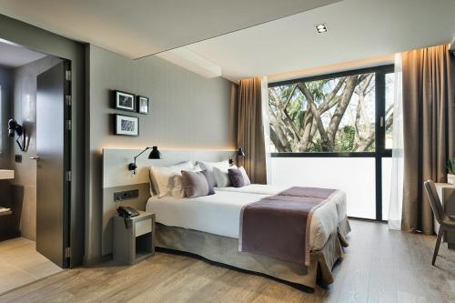 a bedroom with a large bed and a large window at Upper Diagonal in Barcelona