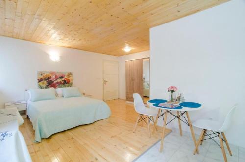 a bedroom with a bed and a table and chairs at St Mary Apartments - Dubrovnik in Dubrovnik