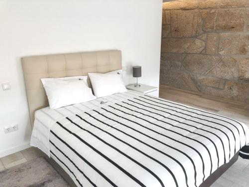 a bedroom with a large bed with a brick wall at House with Private Pool in Cabeceiras de Basto - 250 m² in Cabeceiras de Basto