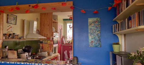 une cuisine avec un mur bleu et des décorations rouges dans l'établissement Chez Janie, à Nantes