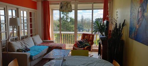 un salon avec un canapé et une grande fenêtre dans l'établissement Chez Janie, à Nantes