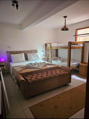 a bedroom with a large bed and a couch at Apto Gostoso andar Cantina in São Miguel do Gostoso