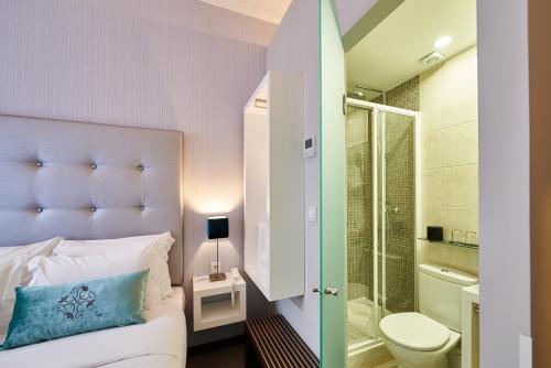 - une chambre avec un lit, une douche et des toilettes dans l'établissement Silk Lisbon, à Lisbonne