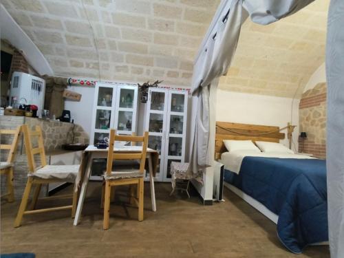 a bedroom with a bed and a table and chairs at Kryptàdion in Grottaglie