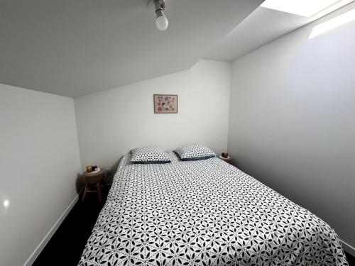 a bedroom with a bed with a black and white comforter at Azur & Serenity in Clermont-Ferrand
