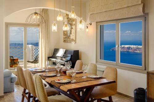 a dining room with a table and chairs with a view of the ocean at Nastazia Residence in Imerovigli