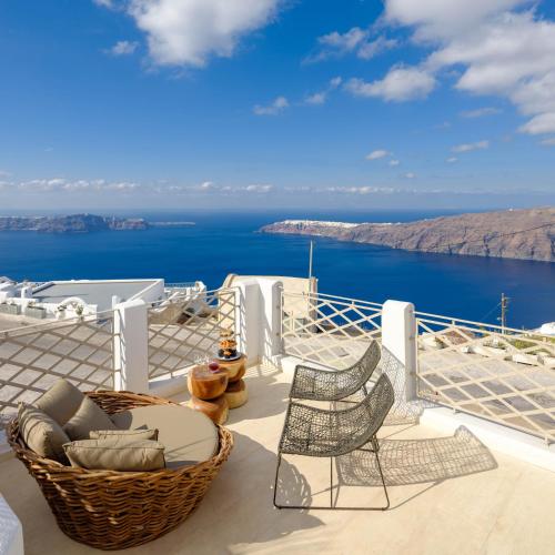 a balcony with two chairs and a table and the ocean at Nastazia Residence in Imerovigli