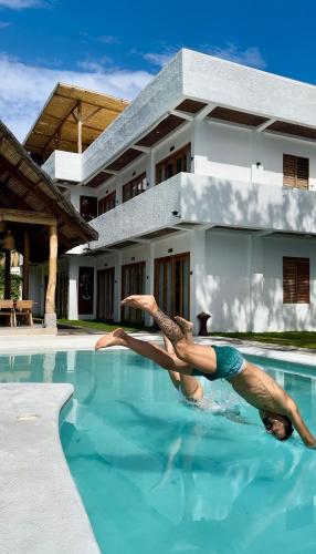 a man laying in the water in a swimming pool at E-Fun Dive Resort in Dauin