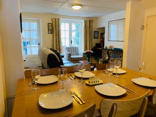 a dining room table with plates and wine glasses at Maypole Cottages No 10 Broad Street Padstow in Padstow