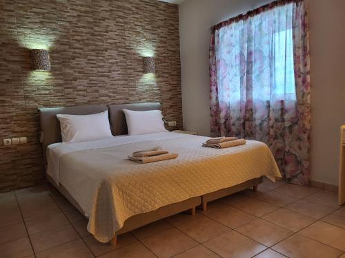 a bedroom with a bed with two towels on it at Ilaira Beach Apartments in Chrani