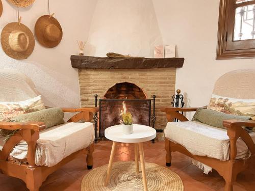 a living room with two chairs and a fireplace at Casa Harillo in Genalguacil