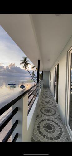a balcony with a view of the beach and the ocean at GOLDEN SUNSET INN in Siquijor