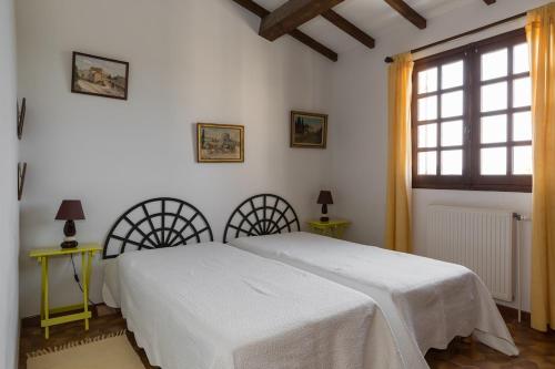a bedroom with a white bed and two tables and a window at La Renardière Provence in Mollans-sur-Ouvèze