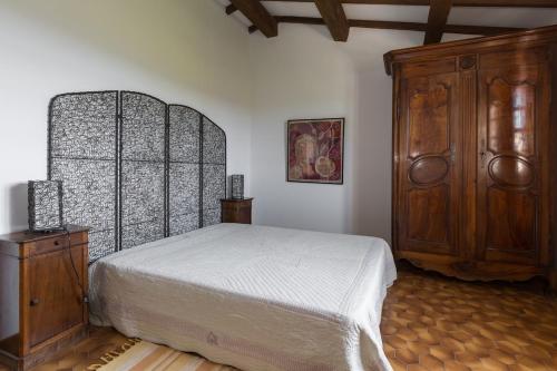 a bedroom with a bed and a wooden cabinet at La Renardière Provence in Mollans-sur-Ouvèze